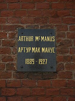 Plaque on a brick wall with inscription: Arthur MacManus/Артур Макманус, 1889–1927