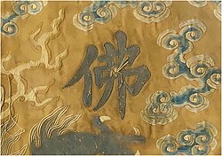 Detail of outer-most burial garment. The loose threads over the Chinese character for Buddha ('佛') was the former position of a sewn pearl, prior to it being violently torn away.