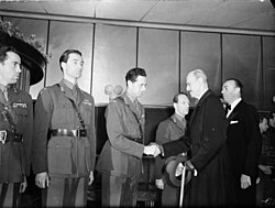 Soldiers in uniform, from the left: Knut Haukelid, Joachim Rønneberg, Jens Anton Poulsson shaking hands with King Haakon VII, Kasper Idland.