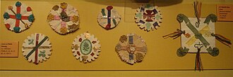 Photograph of eight home-made badges composed of variously coloured crosses and saltires.