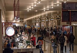 A long hallway with track entrances and food vendors