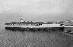 Aircraft carrier on the sea with cloudy sky in the background