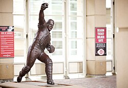 A bronze statue of Johnny Bench throwing out a base runner. Statue is in front of Great American Ball Park in Cincinnati