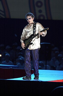 Cavaleri performing onstage with his guitar at the Opening Ceremony of the 2000 Sydney Paralympic Games