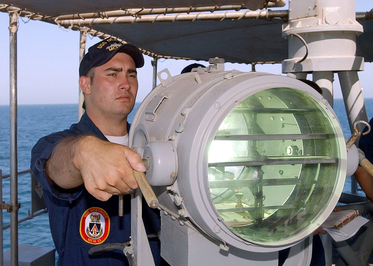 US Navy 020623-N-5329L-007 Signalman 2nd Class Eric Palmer signals the U.S. Navy mine hunter coastal ship USS Raven (MHC 61.jpg