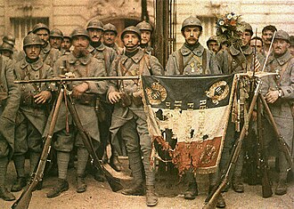 Poilus posing with their war-torn flag in 1917, during the First World War (1914–1918)