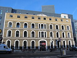 Brick façade in front of a modern, grey‑clad building
