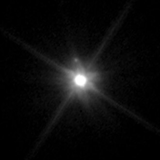A photograph of Makemake and its unnamed moon taken by the Hubble Space Telescope on April 27, 2015. Both Makemake and its moon appear as white dots against a black background.