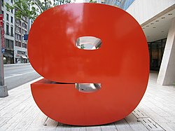 Large red shiny number 9 on a pedestal on a Manhattan sidewalk