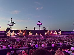 People watching an Adele show lit up with pink lights