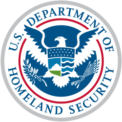 Seal of the United States Department of Homeland Security, consisting of an American bald eagle holding a branch and arrows, superimposed by the shield dividing into three sections containing elements that represent the homeland "from sea to shining sea." The top element, a dark blue sky, contains 22 stars representing the original 22 agencies and bureaus that have come together to form the department. The left shield element contains white mountains behind a green plain underneath a light blue sky. The right shield element contains four wave shapes representing the oceans, lakes and waterways alternating light and dark blue separated by white lines.