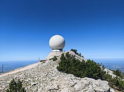 Large spherical weather radar dome on Mont Ventoux against clear sky.