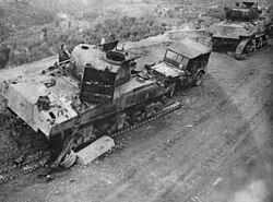 Two damaged tanks with their tracks visibly destroyed and a damaged Willy's Jeep displaying the 6th Armored triangular flash