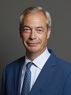 Head shot of Farage slightly smiling in front of a grey background
