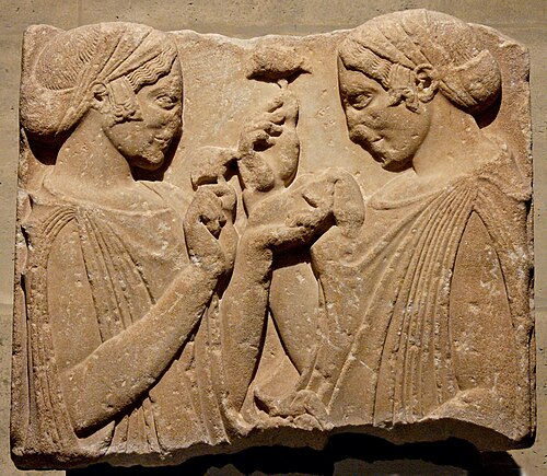 "Exaltation de la Fleur" (exaltation of the flower), fragments from a secondary grave stele: two women wearing a peplos and kekryphalos (hairnet), hold poppy or pomegranate flowers, and maybe a small bag of seeds. Parian marble, c. 470–460 BC. From Pharsalos, Thessaly.