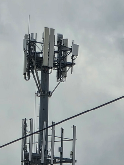 Close-up of antennas and radio units on a monopole tower.
