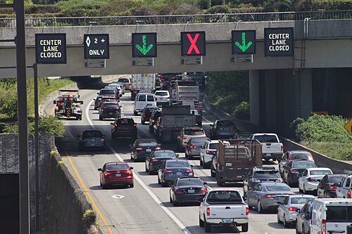 A set of LED signs on Interstate 90 in Mercer Island, Washington, USA, that warn of an upcoming lane closure due to a collision. Normally, these signs display variable speed limits that are adjusted during rush hour.