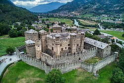 Aerial view of a medieval castle in the middle of a green valley