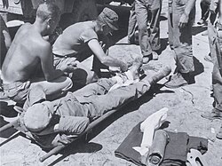 A Hospital Corpsman prepares a wounded Marine for evacuation from a forward aid station in the Yanggu area.