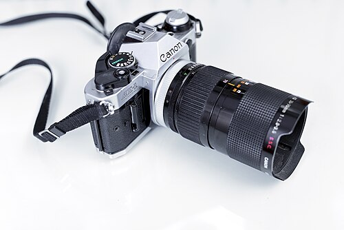 Canon camera with a 35~70 f/2.8~3.5 zoom lens. The advantage of a zoom lens is the flexibility, but the disadvantage is the optical quality. Prime lenses have a greater image quality in comparison.