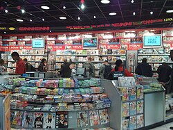 A newsstand showing many magazines. There are TVs showing the news in the background.
