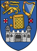 Azure, a Bible closed, clasps to the dexter, between in chief, on a dexter a lion passant, on the sinister a harp, all or, and in base a castle with two towers domed, each surmounted by a banner flotant from the sides, argent, the dexter flag charged with a cross, the sinister with a saltire, gules.