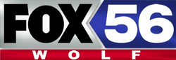 On a silver swallowtail-shaped background, the Fox network logo in black next to a blue pentagonal area containins a white numeral 56. Beneath, in a red bar, are the letters W O L F, widely spaced and in white.