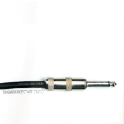 A guitar cable jack plug against a white backdrop