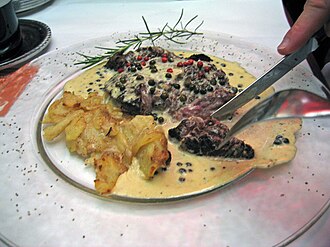 A beef steak served with peppercorn sauce