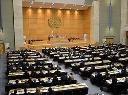 Many people gathered in a large meeting room