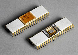 Close up of two small white rectangular microprocessor chips with small gold-colored metallic prongs extending from the side downward. The top left chip has a gold covering on the top middle portion that reads "C8080B, ES 1274, KI984". The bottom right chip has the cover removed exposing the die of semiconducting material.
