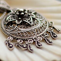 This photo taken with the lens aperture wide open resulting in a narrow depth-of-field and strong axial CA. The pendant has purple fringing in the near out-of-focus area and green fringing in the distance. Taken with a Nikon D7000 camera and an AF-S Nikkor 50 mm f/1.8G lens.