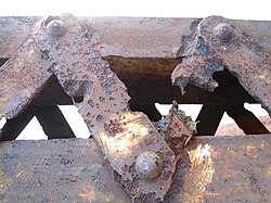 Rusted and pitted struts of the 70-year-old Nandu River Iron Bridge
