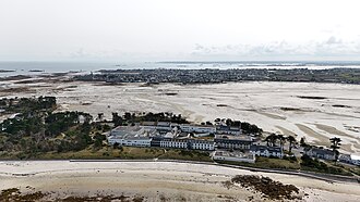 Aerial photograph of the Perharidy medical complex in Roscoff, located beside wide tidal flats along the Brittany coastline.