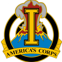 A gold device containing a gold letter I superimposed over an erupting volcano, with the words "America's Corps" at the bottom