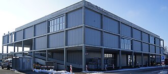 Outside view of a large concrete building. At the top of the building is a sign reading "Enter Technikwelt".