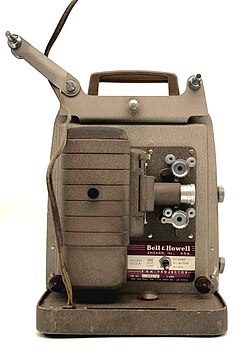 A 1950s Bell & Howell Monterey 8mm movie projector, Model 253-A. Features a tan crinkle finish and industrial Mid-Century Modern design. Tested and fully functional.