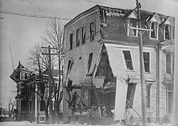 Building with walls bent outward and floor collapsing