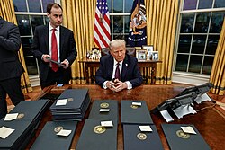 Trump surrounded by stacks of executive orders