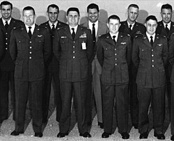 Nine members, eight in uniform, standing for a class photo.
