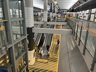 Large underground concourse with escalators and lifts down to platform level and up to ground level