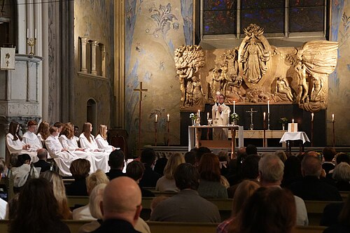 A priest of the Church of Sweden elevates the host during a Confirmation Mass at Oscar's Evangelical-Lutheran Church on the Third Sunday of Eastertide
