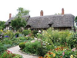 An old thatched cottage set within colourful gardens