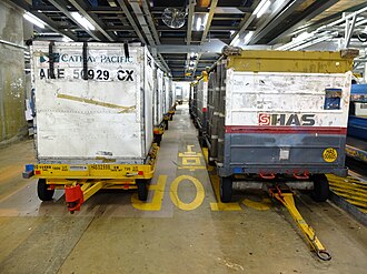 Those on the left are dollies from Cathay Pacific for baggage unit load devices (ULDs). Those on the right are dollies for loose baggage.