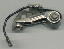 Breaker arm with contact points at the left. The pivot is on the right and the cam follower is in the middle of the breaker arm.