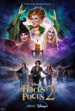 Three witches dressed in bright colors, at the top of the poster. Beneath are three girls, two wheeling bicycles.