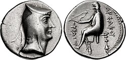 Two sides of a silver coin. The one on the left bears the imprint of a man's head, while the one on the right a sitting individual.