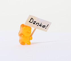 A gummi bear holding a sign that says "Thank you"