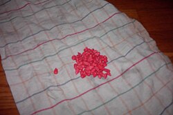Corn kernels treated with taint, a fungicide. Sifering agents are provided with a dye for identification, since tainted goods are excluded from feeding.