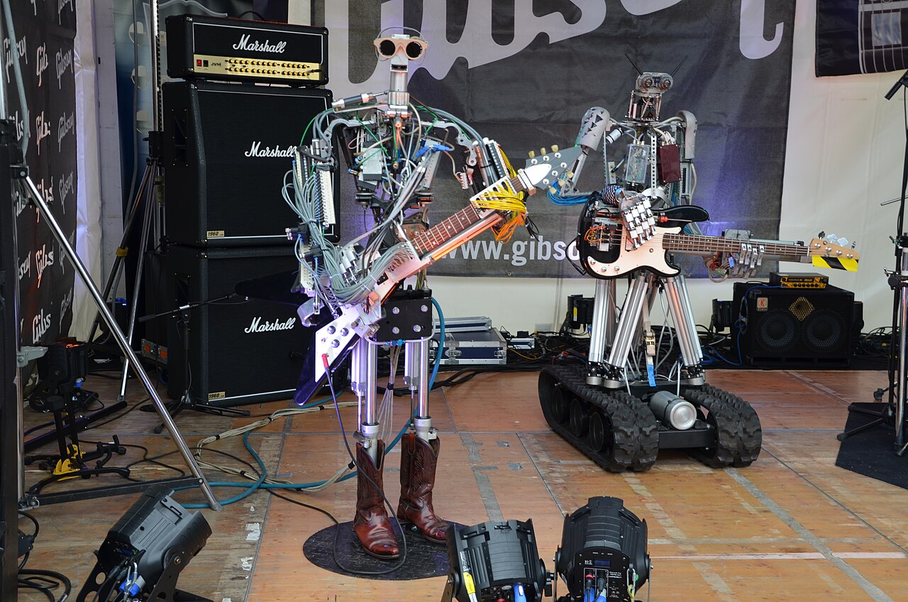 Compressorhead - Fingers on Gibson Flying V, Bones on Fender Precision Bass - Musikmesse Frankfurt 2013.jpg